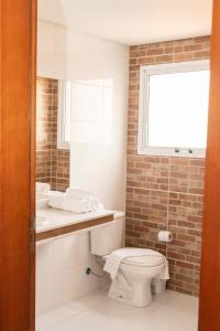 een badkamer met een toilet, een wastafel en een raam bij Hotel Jabuticaba in Sao Paulo