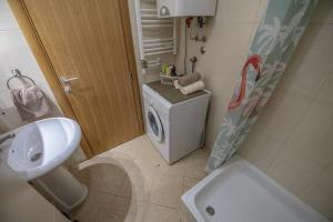 a bathroom with a washing machine and a washer at Stella Modern Apartment 2 in Novi Sad +9 photos