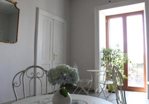 a dining room with a table with a vase of flowers at N'Art Suites - Napoli in Naples