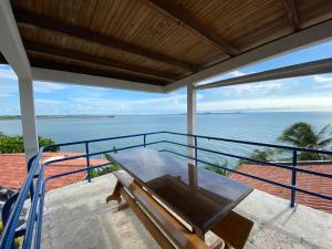 balcón con mesa y vistas al océano en Casa Miramar, en Santa Marta