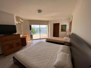 a hotel room with two beds and a television at Casa Miramar in Santa Marta +21 photos