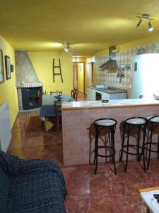 a kitchen with a counter and stools in a room at Manxalo in Sant Mateu