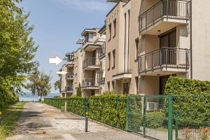 an apartment building with a fence in front of it at Panoramic Art Apartment with jacuzzi in Balatonlelle
