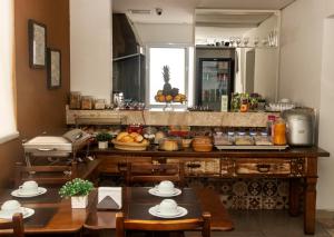 a kitchen with two tables and a counter with food at Hotel Jabuticaba Expo Center Norte in São Paulo