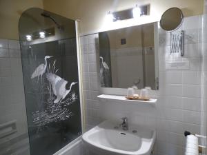 een badkamer met een wastafel en een spiegel bij Hôtel Ambroise in Uzerche