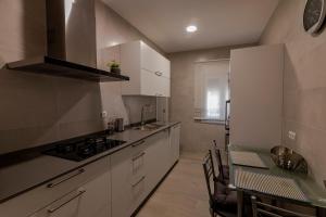 a kitchen with white cabinets and a table and a stove at Casa Jordi in Valderrobres