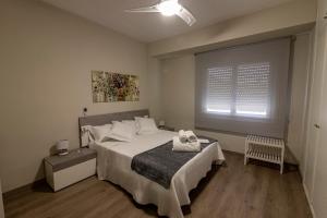 Schlafzimmer mit einem großen weißen Bett und einem Fenster in der Unterkunft Casa Jordi in Valderrobres