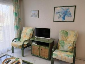 ステラ・プラージュにあるAppartement Floraのリビングルーム(椅子2脚、薄型テレビ付)