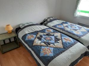 ステラ・プラージュにあるAppartement Floraのベッドルームに掛け布団付きのベッド1台