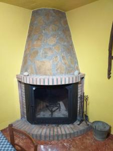a stone fireplace in a room with a yellow wall at Manxalo in Sant Mateu