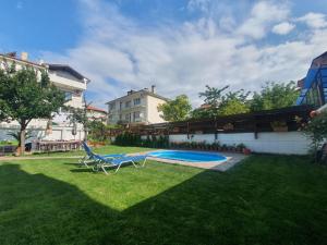 a yard with a chair and a swimming pool at Cherry Garden Apartments in Sveti Vlas