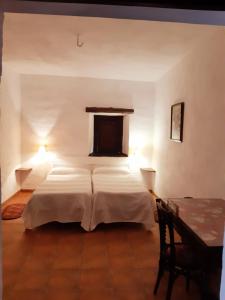 1 dormitorio con 2 camas y mesa en El Aleznal, en Trujillo