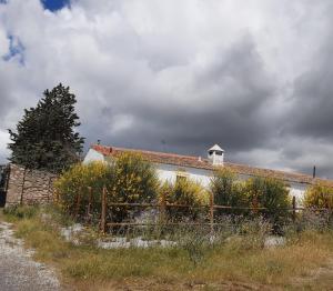 un edificio blanco con techo rojo y valla en El Aleznal en Trujillo