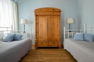 a bedroom with two twin beds and a wooden cabinet at Karlamuiza Country Hotel in Kārļi