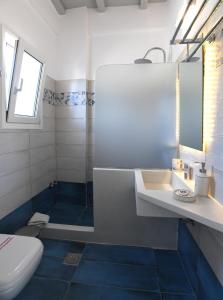 a bathroom with a tub and a sink and a toilet at Nostos Beachfront Apartments & Studios in Agios Ioannis