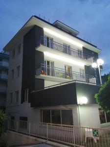 Edificio alto de color blanco con balcón en Hotel Brennero, en Rímini
