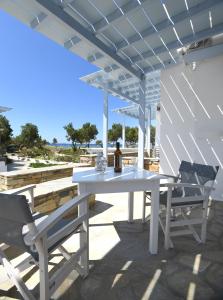 a white table and chairs on a patio at Nostos Beachfront Apartments & Studios in Agios Ioannis