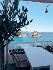 a white table and chairs on a balcony overlooking the ocean at Avra in Parga
