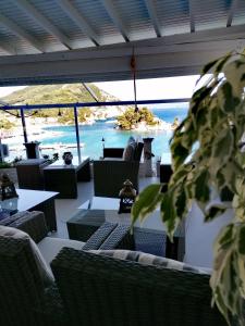 a patio with chairs and tables and a view of the ocean at Avra in Parga