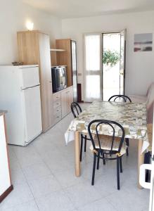 a kitchen with a table and chairs and a refrigerator at Casa Vacanze La Bandera 1 in Santa Teresa Gallura