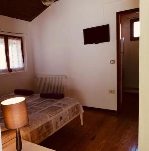 ein Schlafzimmer mit einem Bett und einem TV an der Wand in der Unterkunft Lake Como Cottage in Gravedona