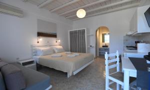 a bedroom with a bed and a living room at Nostos Beachfront Apartments & Studios in Agios Ioannis