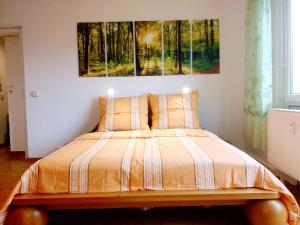 1 cama en un dormitorio con una pintura en la pared en Helles Apartment mit Balkon am Großen Garten nahe Stadtzentrum en Dresden