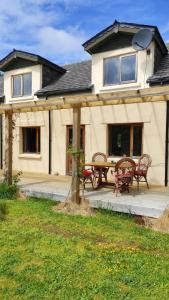 a house with a patio with a table and chairs at Sunrise House in Inverfarigaig