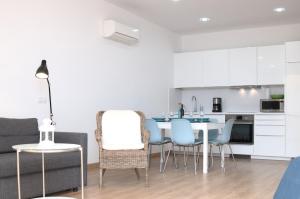 SUITE PLAYA Y MAR - sea view, wifi and AC في ميلينارا: مطبخ وغرفة معيشة مع طاولة وكراسي