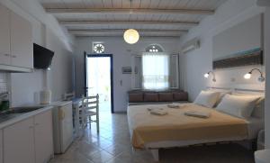a kitchen and a bedroom with a bed in a room at Nostos Beachfront Apartments & Studios in Agios Ioannis