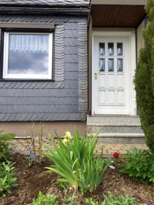 ein Haus mit einer weißen Tür und einem Fenster in der Unterkunft Ferienhaus am Rennsteig in Schmiedefeld am Rennsteig