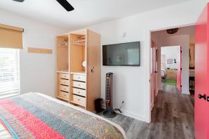 1 dormitorio con 1 cama y TV en la pared en Folly Vacation Perfect Purple Palace Apt A, en Folly Beach