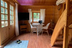 ein Zimmer mit einem Tisch und Stühlen in einer Hütte in der Unterkunft Blockhütte in Rostock Land in Papendorf