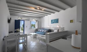 a white living room with a couch and a table at Nostos Beachfront Apartments & Studios in Agios Ioannis