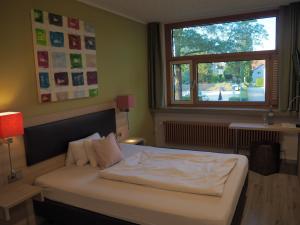 a bedroom with a white bed and a window at Hotel „Zur Linde“ in Ehingen