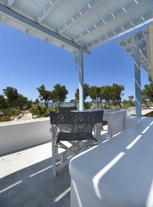 a bench on a roof with a view of the ocean at Nostos Beachfront Apartments & Studios in Agios Ioannis