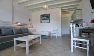 a living room with a couch and a table at Nostos Beachfront Apartments & Studios in Agios Ioannis