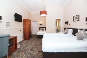 Postel nebo postele na pokoji v ubytování Kelvingrove Hotel - Sauchiehall St