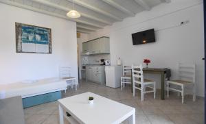 a living room with a kitchen and a dining room at Nostos Beachfront Apartments & Studios in Agios Ioannis