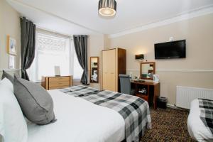 Postel nebo postele na pokoji v ubytování Kelvingrove Hotel - Sauchiehall St