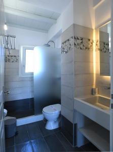 a bathroom with a toilet and a sink at Nostos Beachfront Apartments & Studios in Agios Ioannis