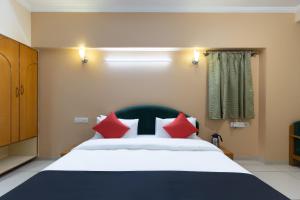 Un dormitorio con una cama grande con almohadas rojas. en Hotel Foliage, en Jamnagar 26 fotos más