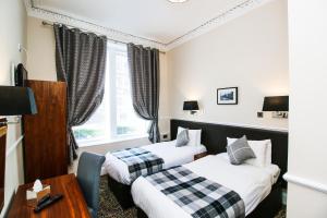 A bed or beds in a room at Kelvingrove Hotel - Sauchiehall St