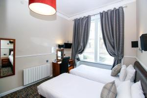 Postel nebo postele na pokoji v ubytování Kelvingrove Hotel - Sauchiehall St