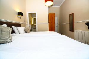 Postel nebo postele na pokoji v ubytování Kelvingrove Hotel - Sauchiehall St