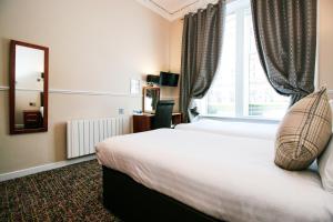 Postel nebo postele na pokoji v ubytování Kelvingrove Hotel - Sauchiehall St