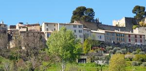 a town on a hill with houses and trees at L'Ensoleillée in Ménerbes