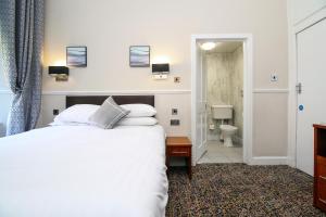 Postel nebo postele na pokoji v ubytování Kelvingrove Hotel - Sauchiehall St