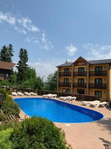 a swimming pool in front of a large building at Idylia Grand Villas in Migovo