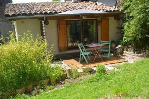 a small house with a table and chairs on a deck at Petit Gîte TARA avec SPA - Ariege Pyrénées in Péreille